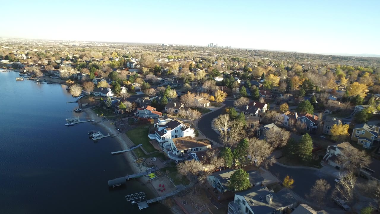 Aerial view of lakeside houses and tree-lined streets.