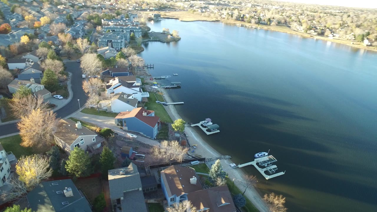 Aerial view of lakeside homes, docks, boats, and a wide lake.