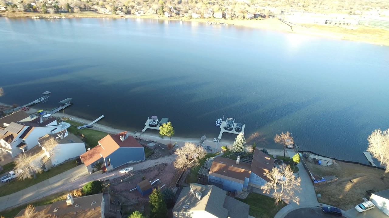 Aerial view of shoreline homes, docks, and a large body of water.