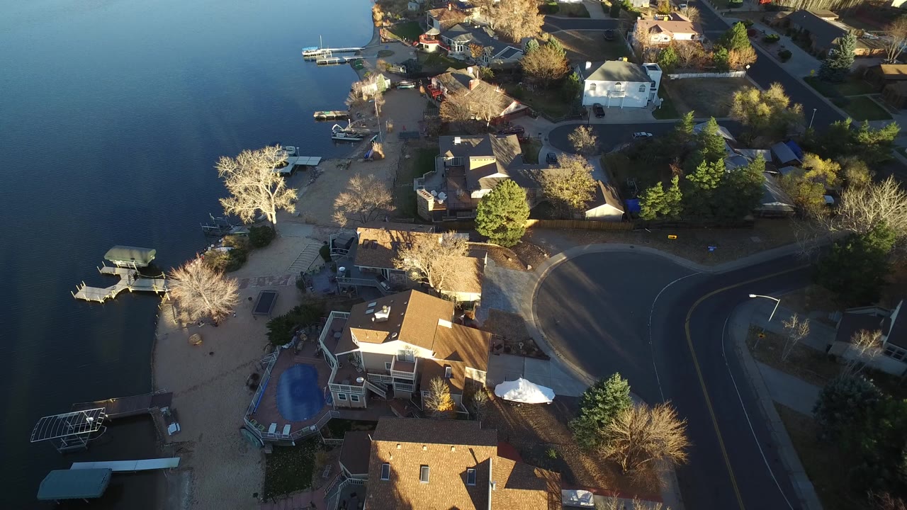 Lakeside neighborhood viewed from above with homes and a curved street.