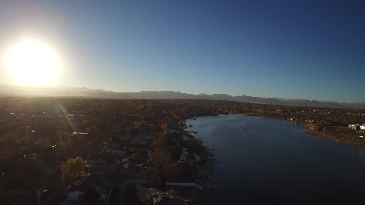 Aerial view of a lake beside suburbs at sunset