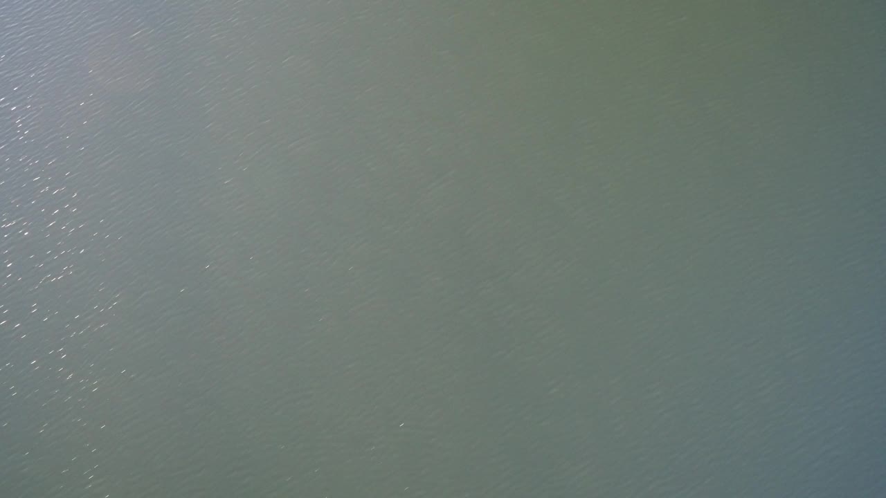 A Westminster, Colorado water detail shows fine surface ripples with a brighter vertical cluster of reflections near the middle, with no visible people.