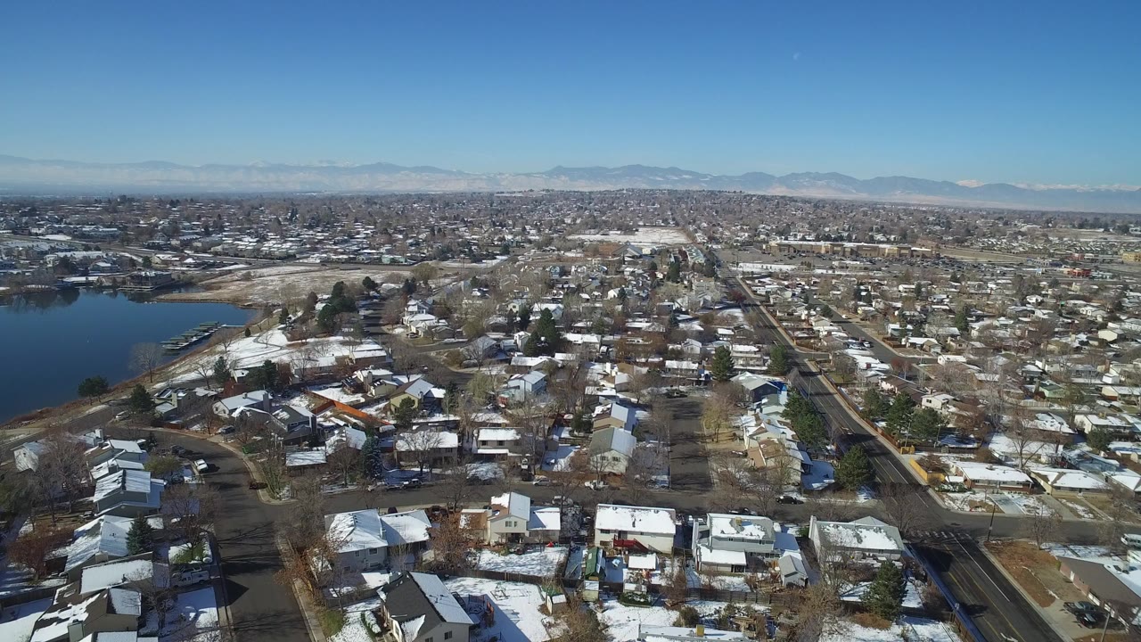 Aerial view of residential streets beside a lake under a clear blue sky.