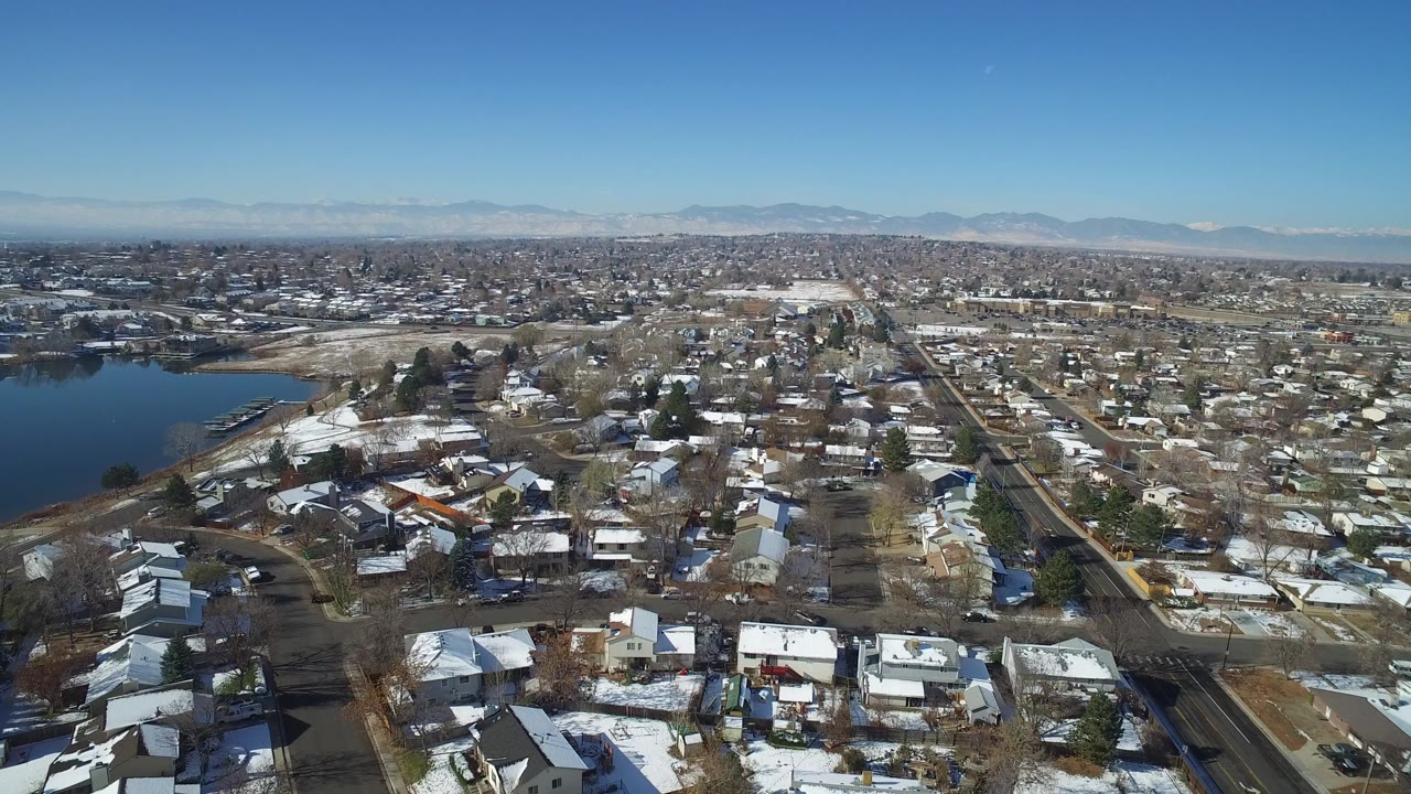 Aerial view of snowy residential streets beside a lake