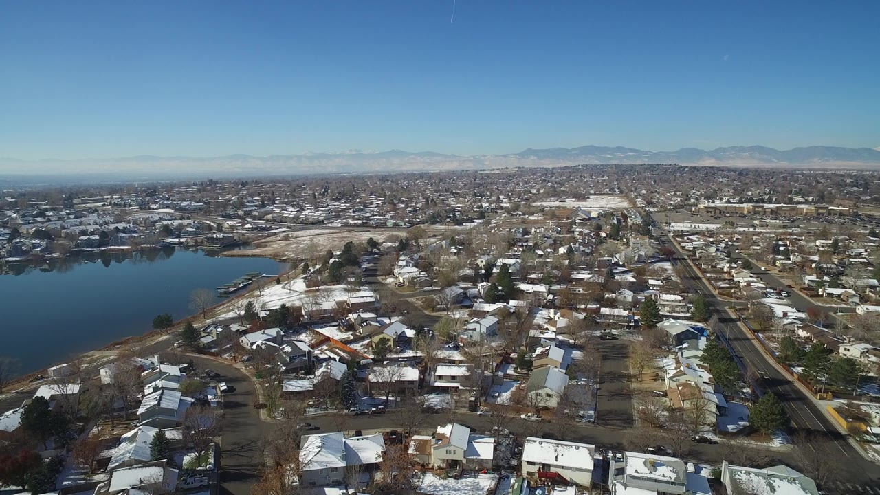Aerial view of homes near a lake with mountains in the distance.