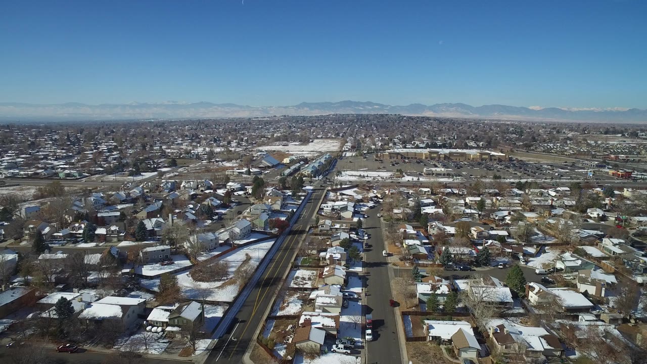Aerial view over snowy residential streets and rail tracks
