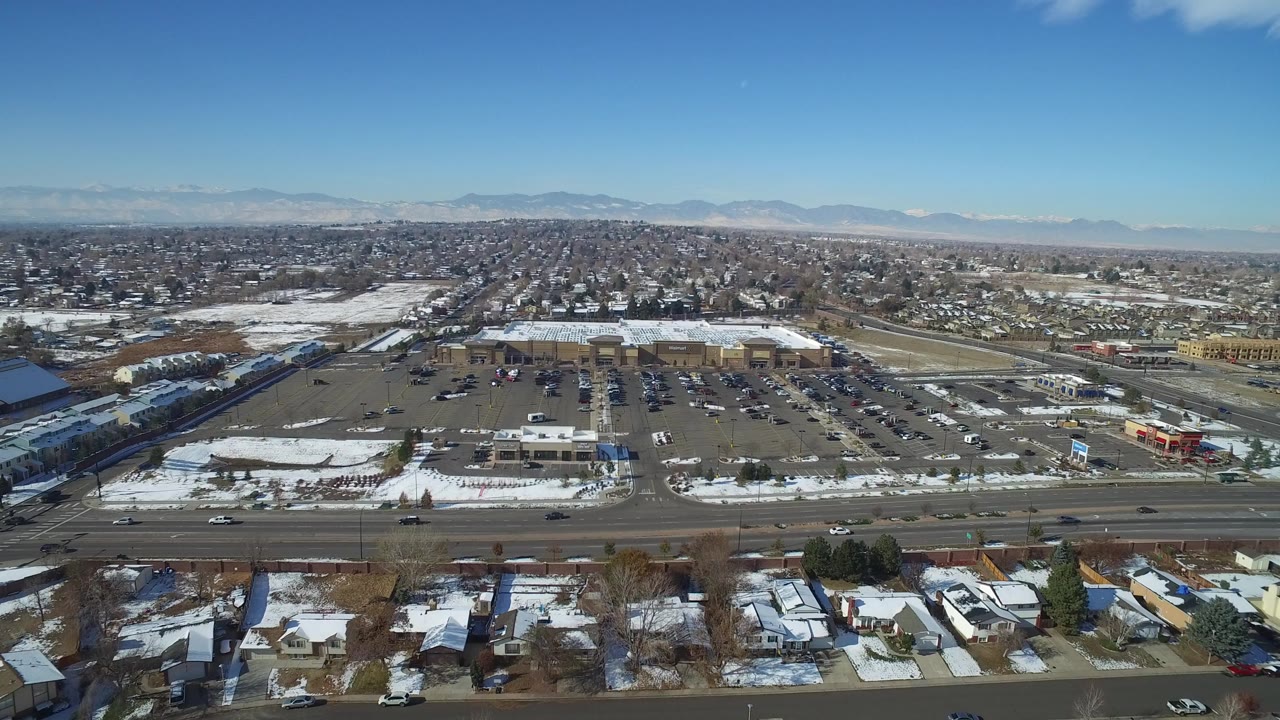 Aerial view of suburban roads, parking lots, homes, and distant mountains