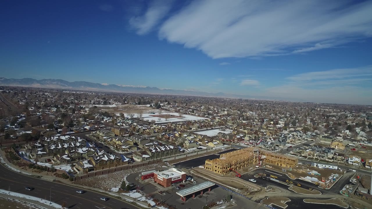 Elevated view across suburban rooftops toward distant mountains.