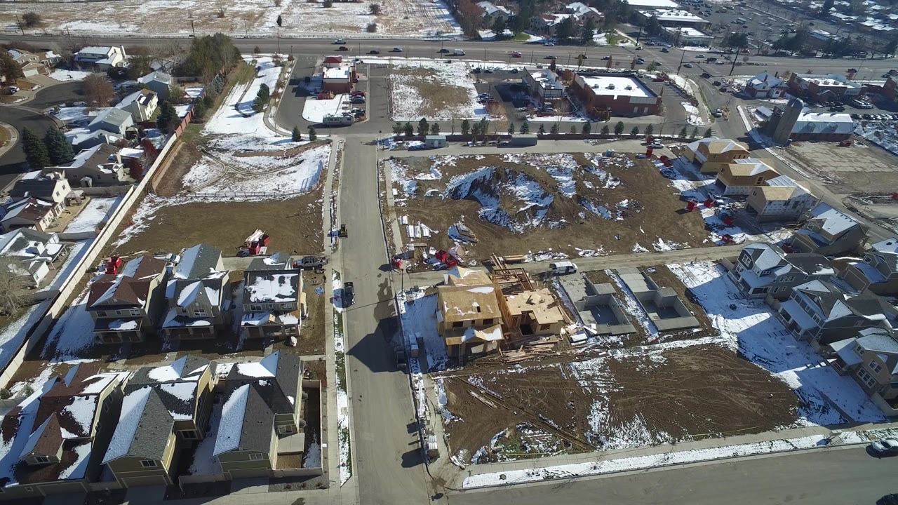 High aerial view of Hidden Lake, Colorado showing residential streets, detached homes, open building lots, patchy snow, and no visible people.