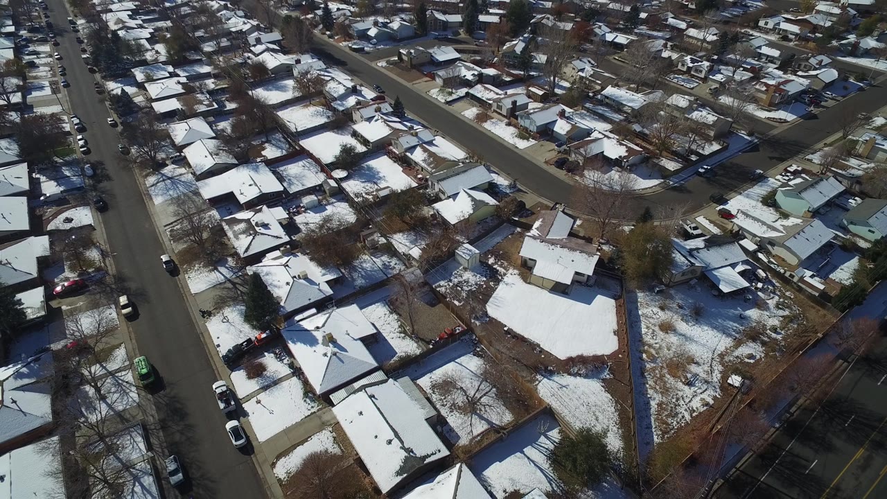 Residential blocks seen from above with patchy snow and streets.