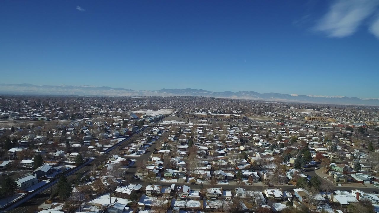 Aerial view of snowy residential blocks under a blue sky