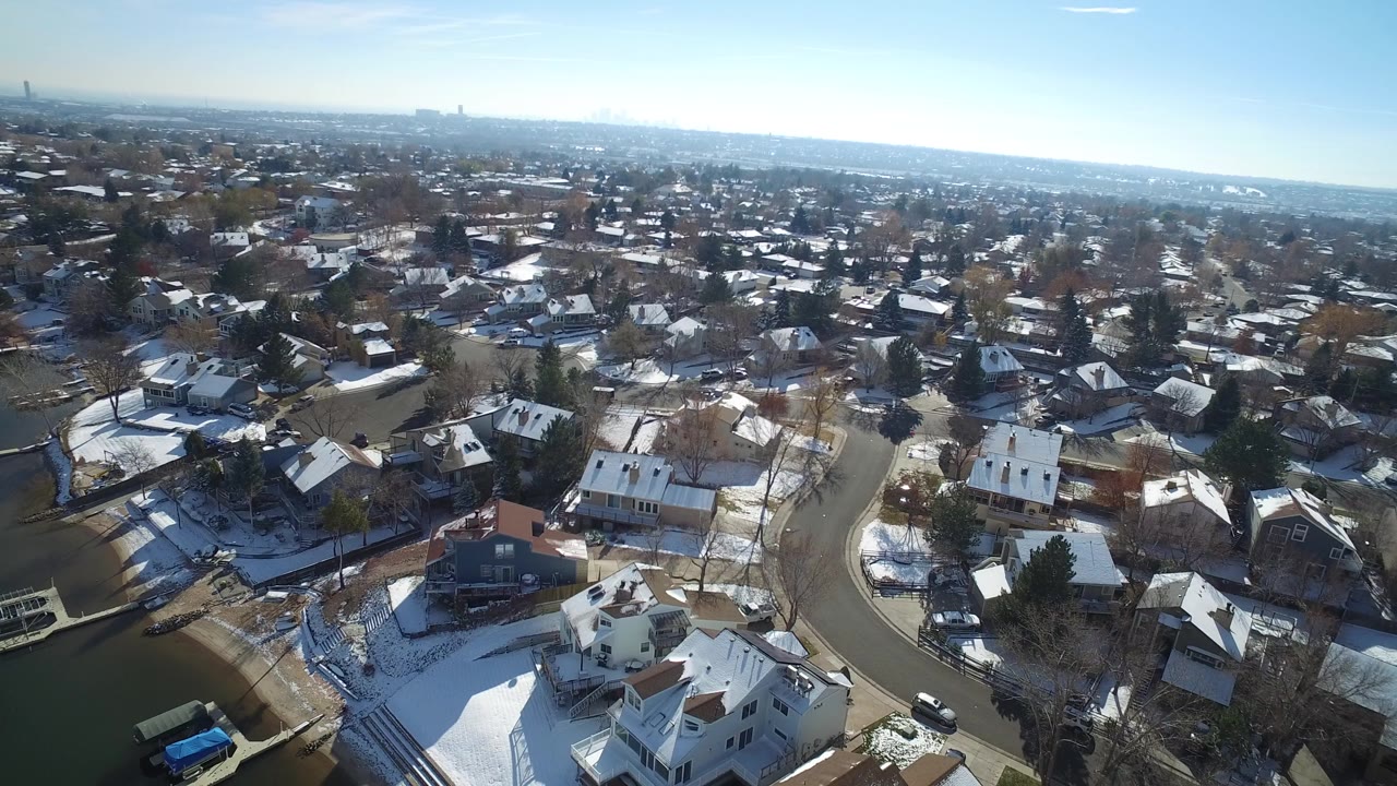 Aerial view of snowy residential streets and houses.