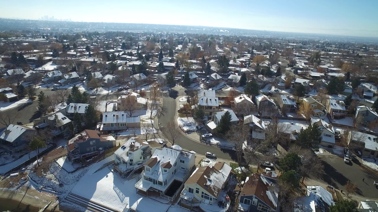 Aerial view of snow-dusted suburban homes and curved residential streets.