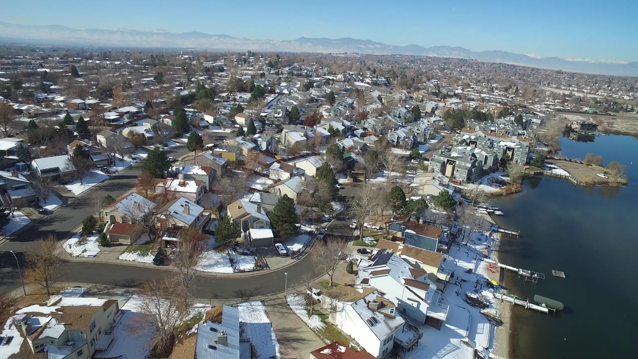 Aerial view of snow-dusted homes beside a lake