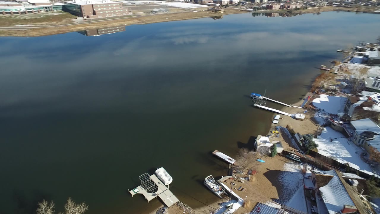 Elevated view over lake water and snowy shoreline docks.