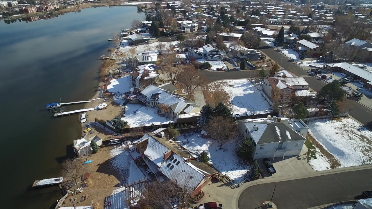 Lake shoreline neighborhood with docks, houses, and winter ground cover
