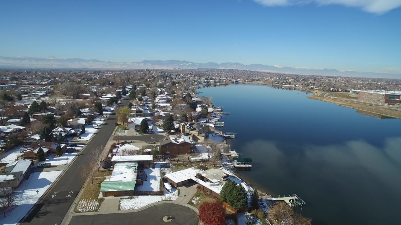 Aerial view of snowy homes beside a blue lake