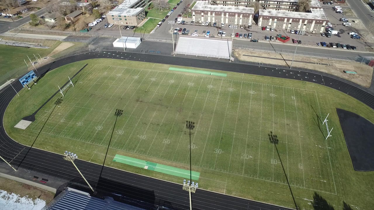 Aerial view of an empty football field inside a running track.