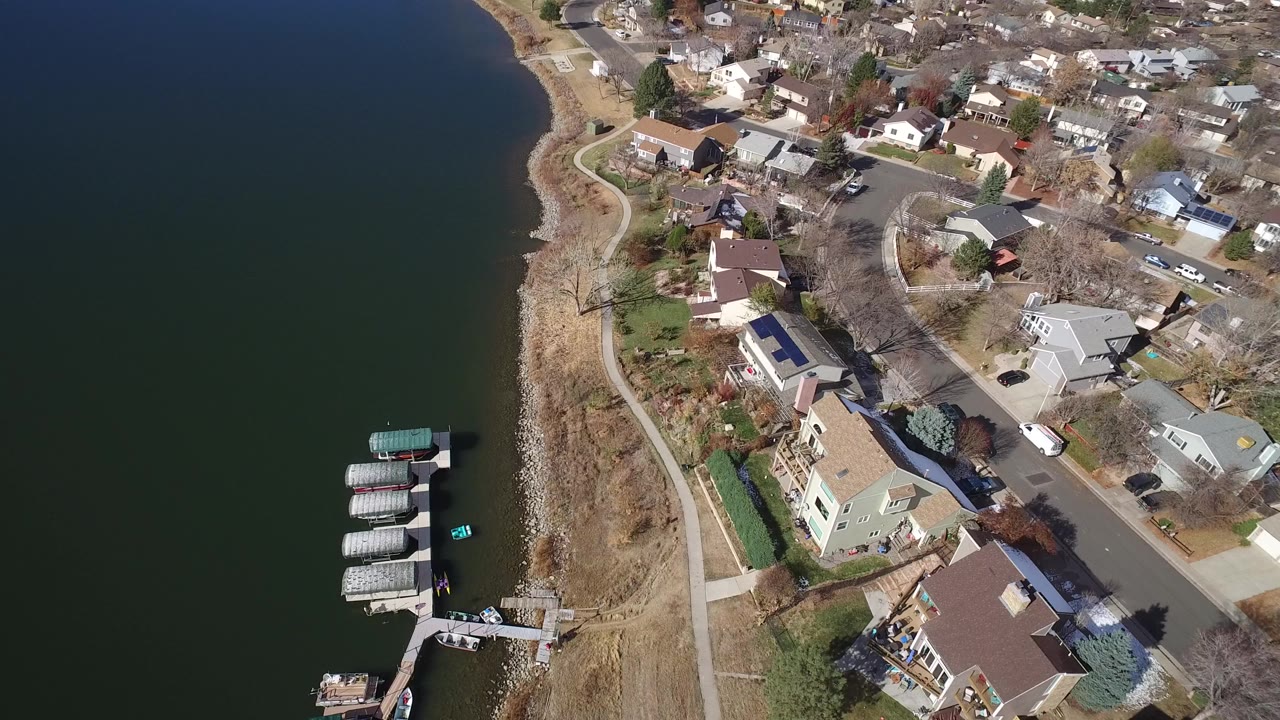 Aerial view of lake shoreline, homes, streets, docks, and boat slips.