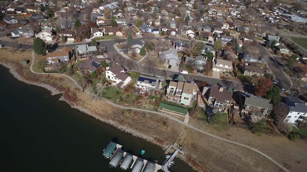 Aerial view of lakefront houses and a shoreline path.