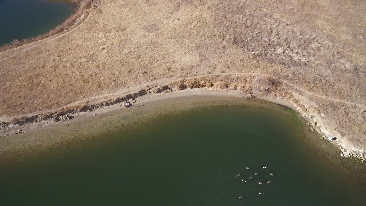 Overhead shoreline with green water and dry brown land.