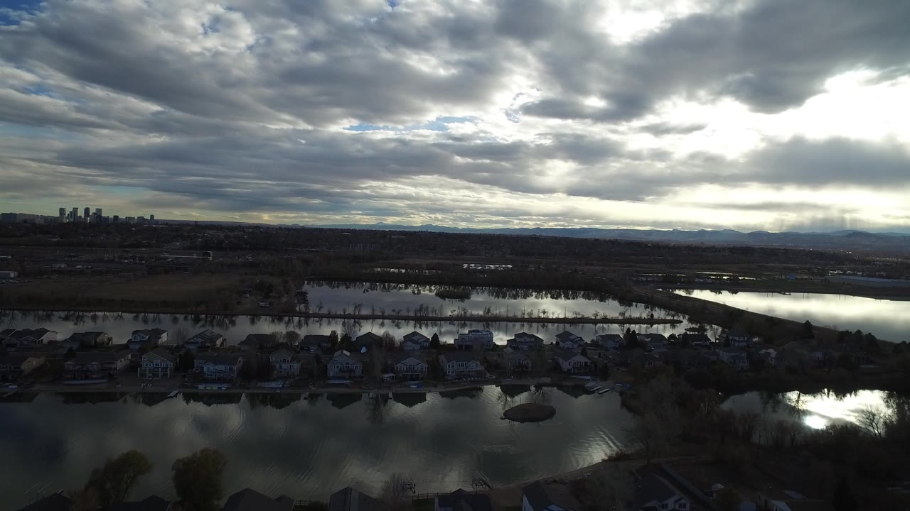 Aerial view of lakeside homes under heavy clouds.