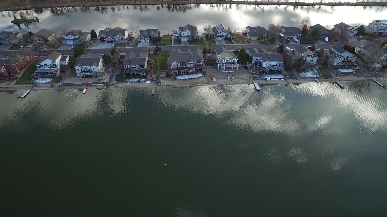 Aerial view of rippled water beside lakeside homes.