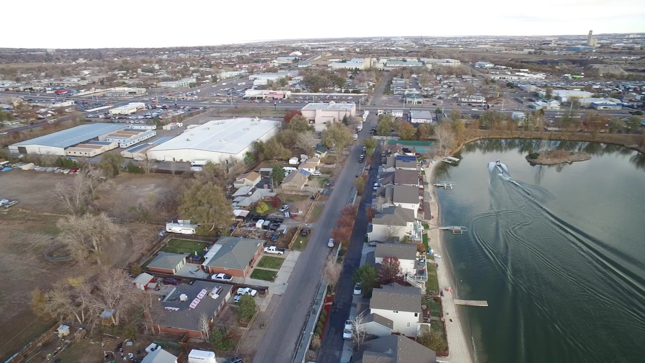 Aerial view of homes beside a road and a small lake.
