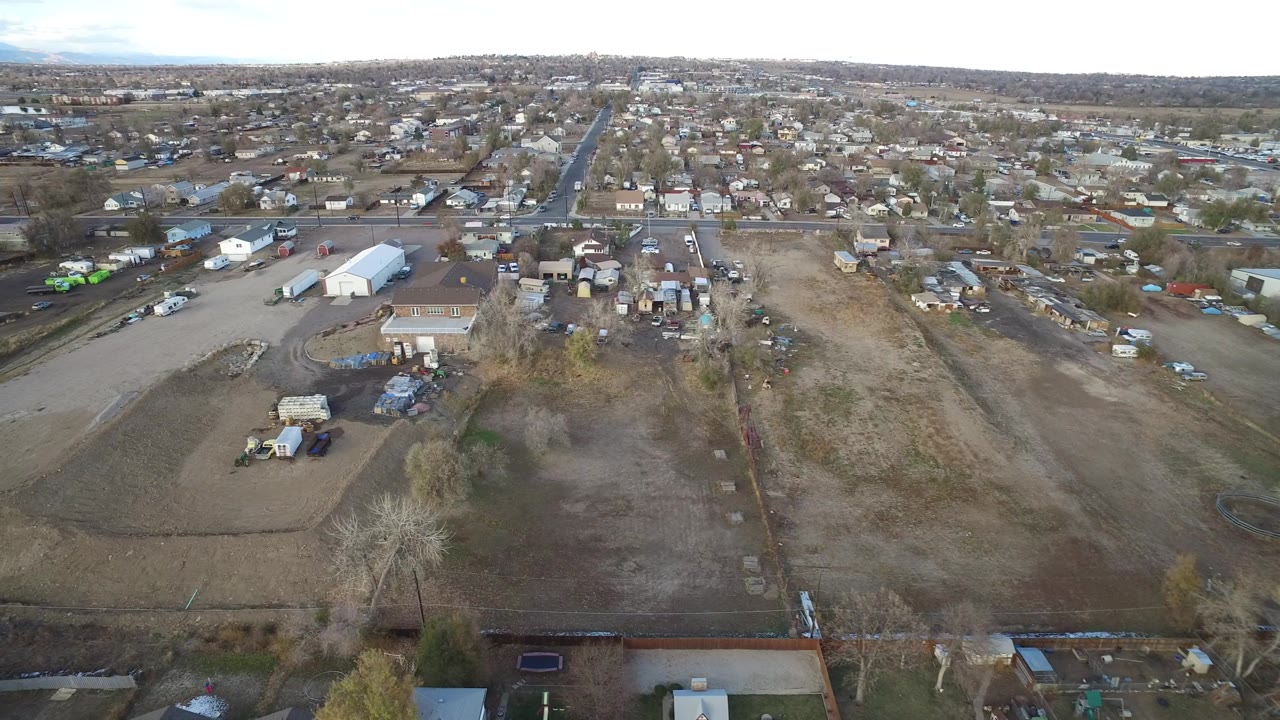 Aerial view of industrial yards, warehouses, roads, and houses.