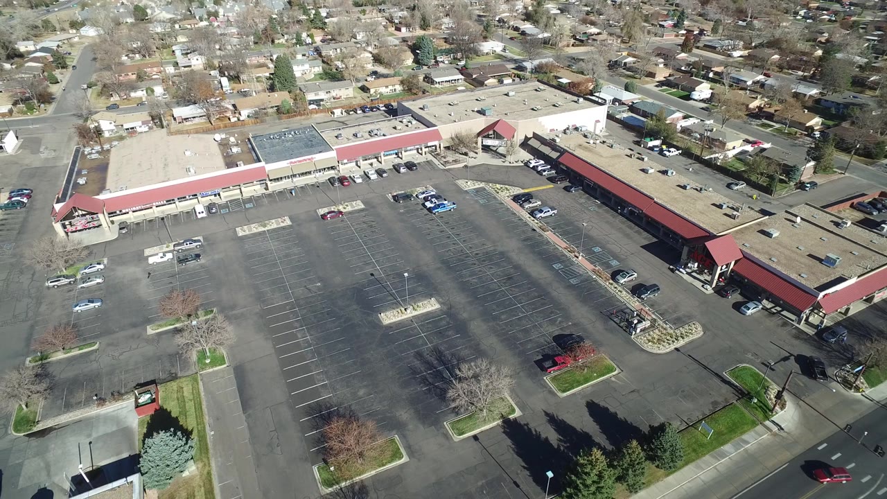 Drone view of a retail parking lot near suburban roads.