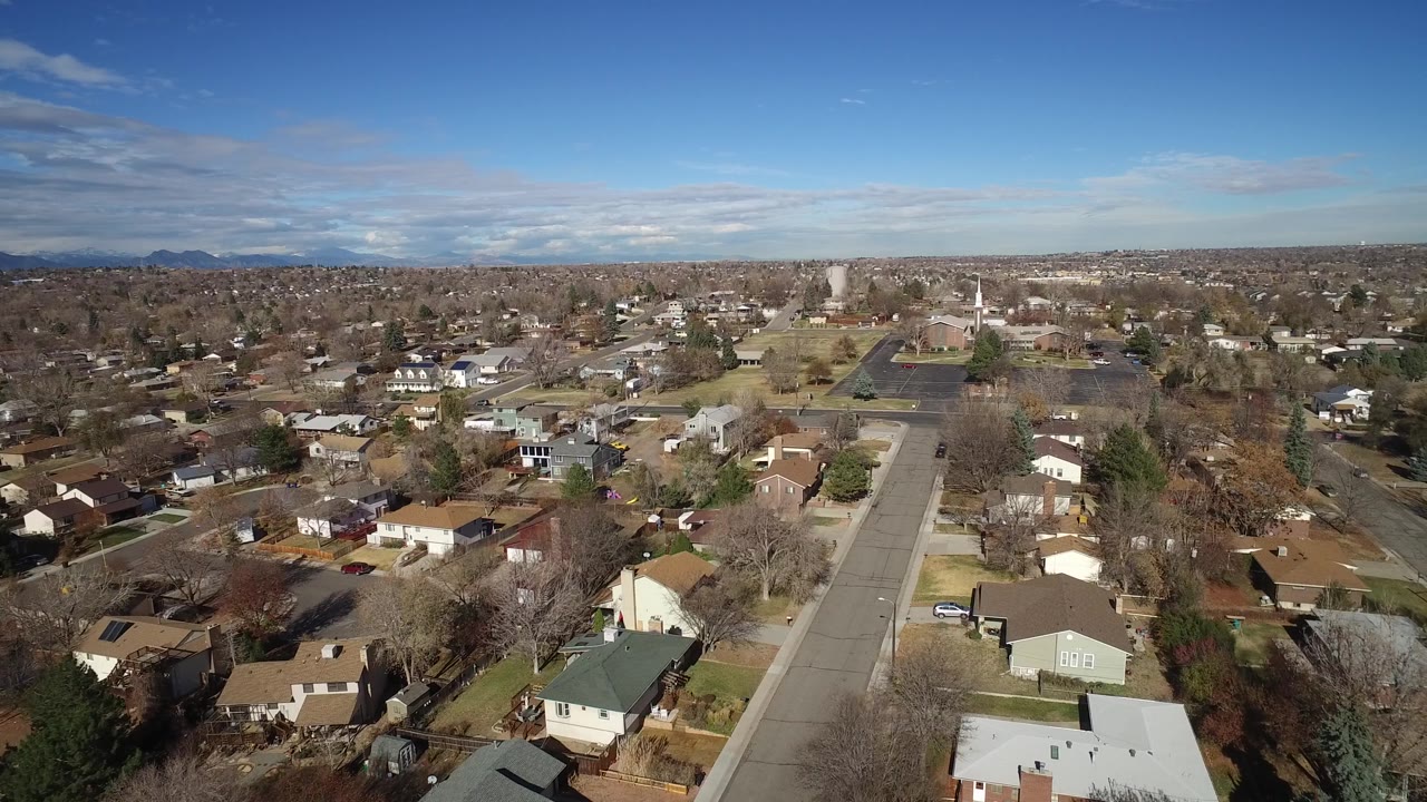 High view of a suburban street with houses and winter trees.