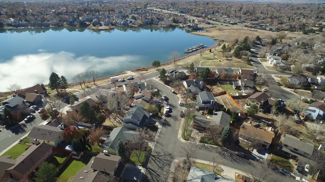 Aerial view of homes beside a blue lake or pond