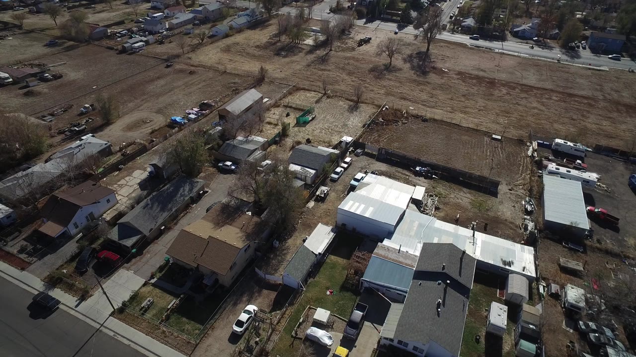 Aerial view of houses, yards, roads, and dry open ground.