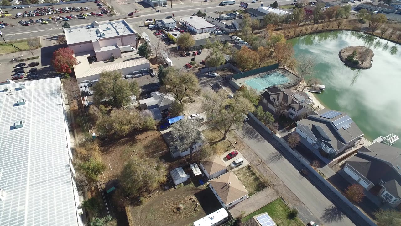 Overhead suburban block with pond, homes, roads, and parking lots.