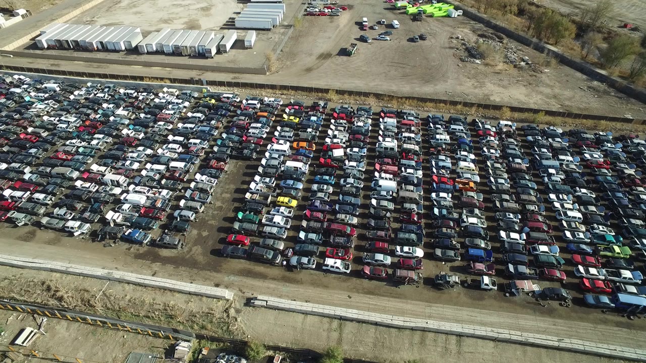 Aerial view of a large car lot with rows of parked vehicles.