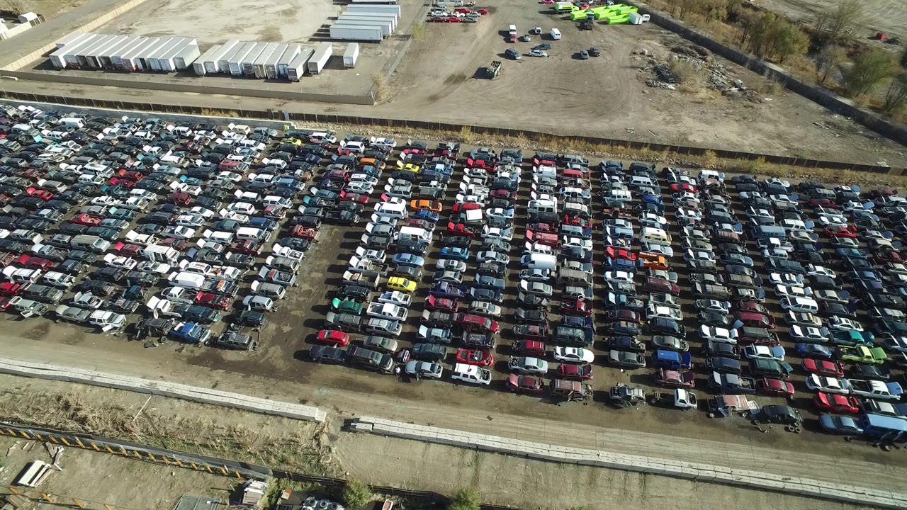 Second aerial frame of the Westminster, Colorado lot, showing packed vehicle rows across the lower half, pale storage trailers in the background, open gravel yard, and no visible people.