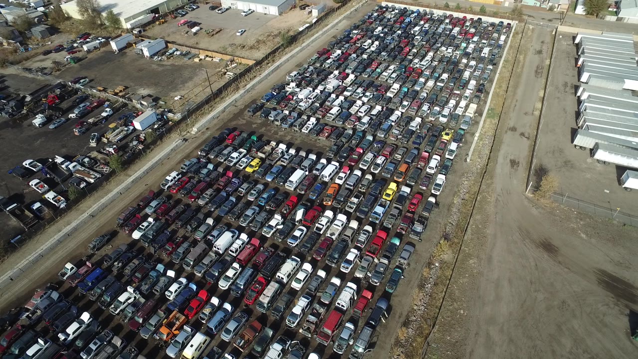 Overhead drone-style view of a packed lot with many colored vehicles.