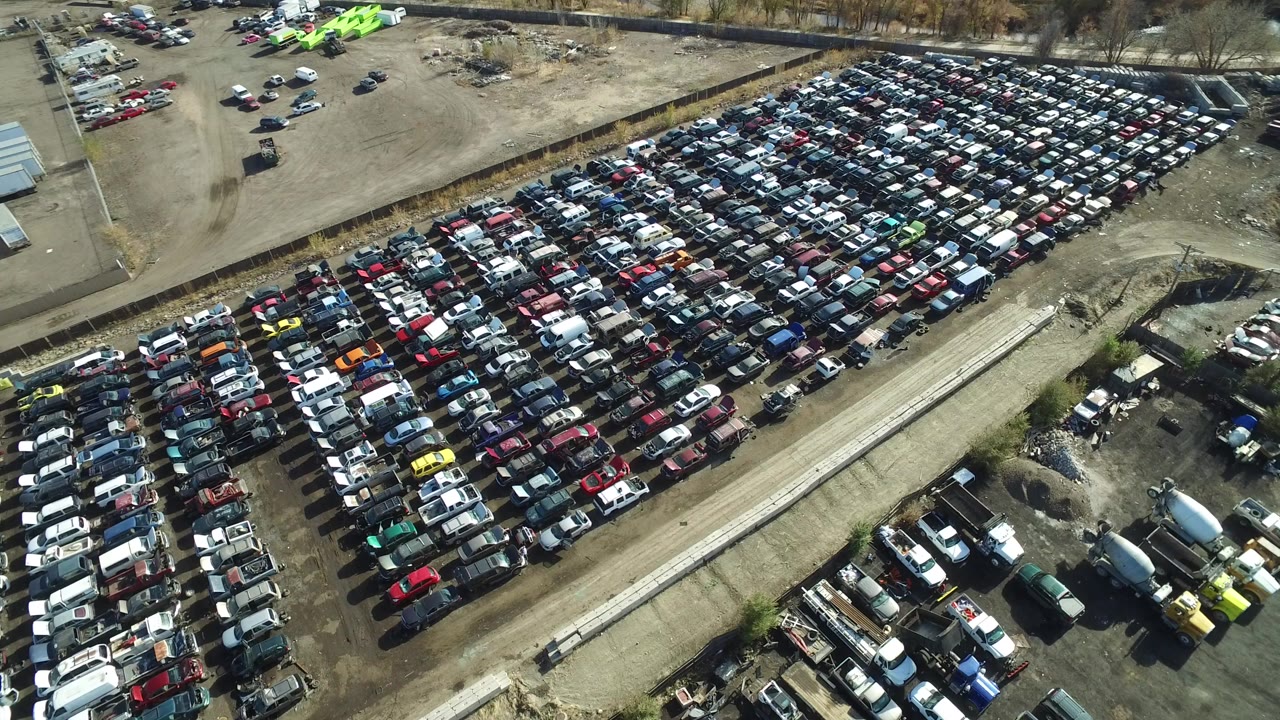 Aerial view of tightly packed cars in a dirt lot