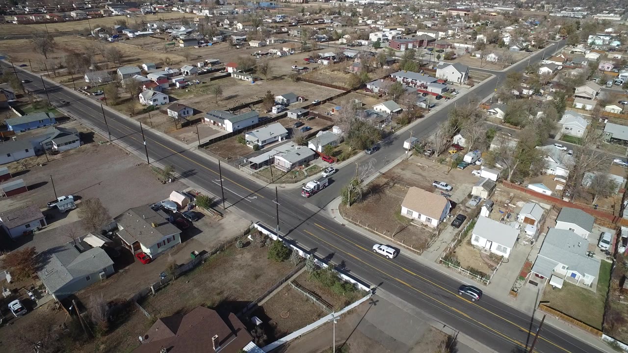 Aerial view of a broad road crossing residential streets and homes.