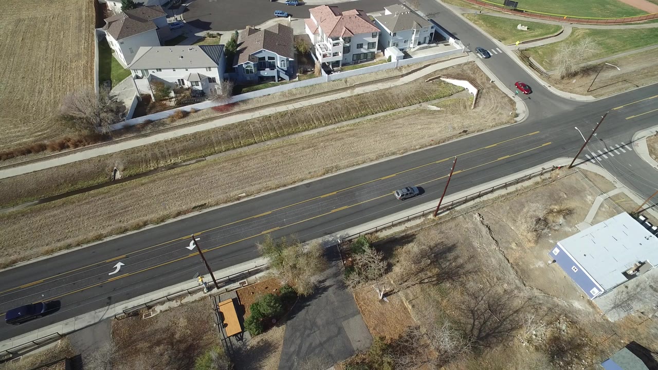 Aerial view of suburban homes beside a multi-lane road.