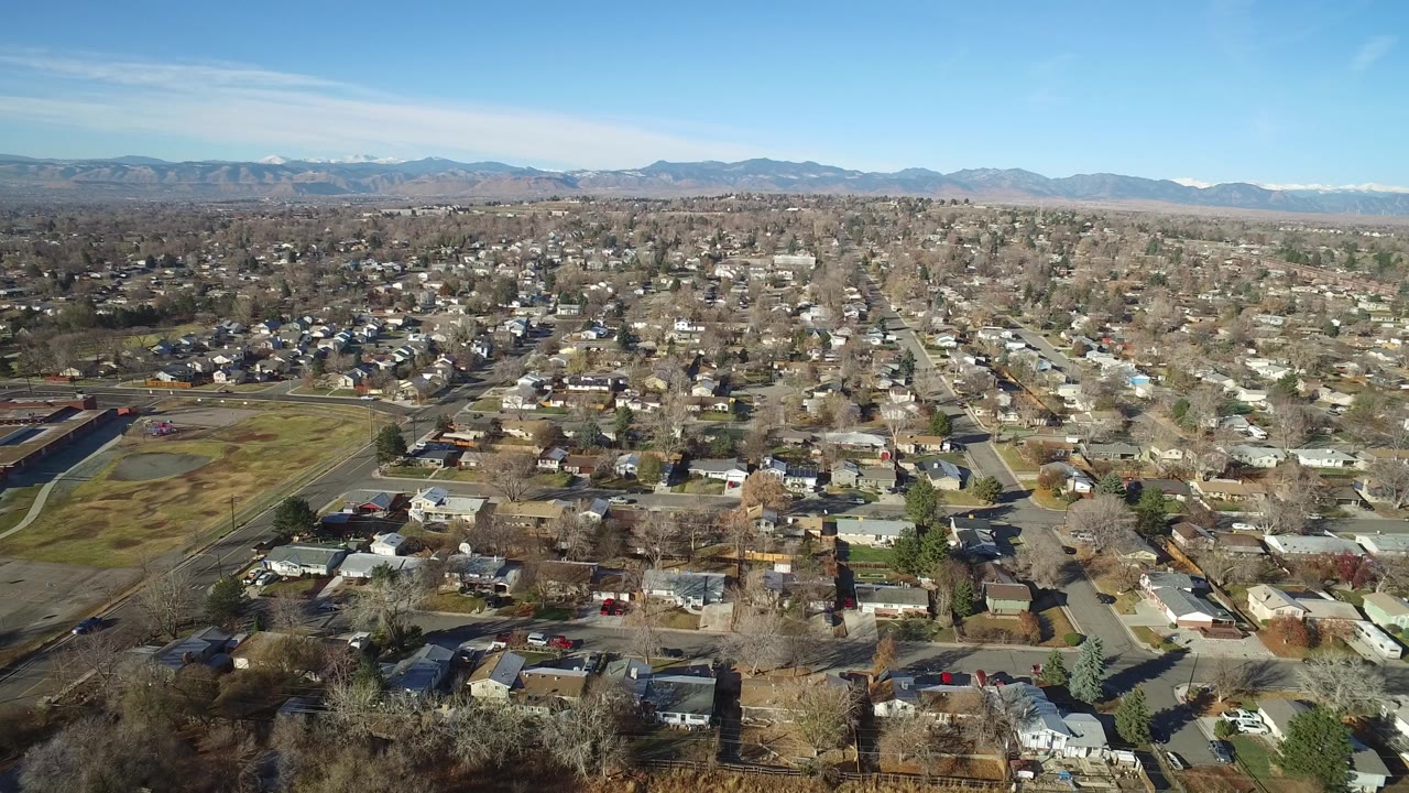 Aerial view over suburban homes and distant mountains