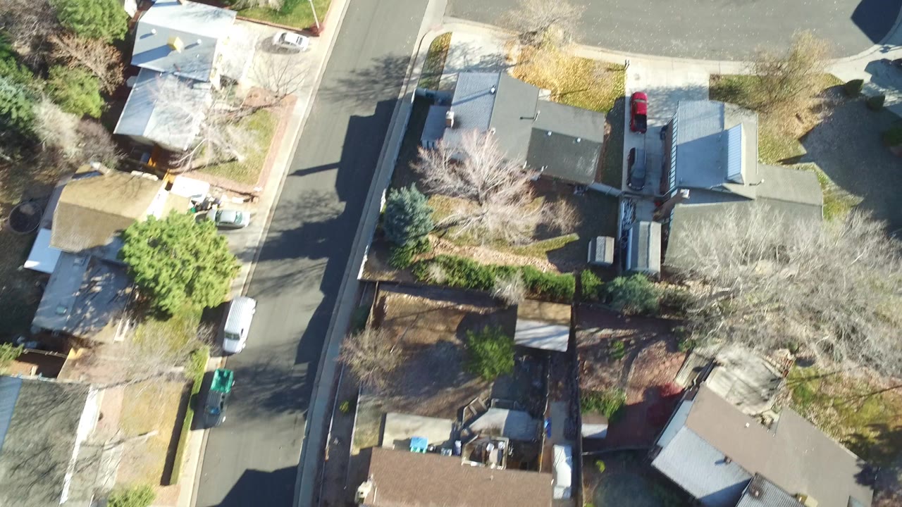 Top-down view of neighborhood houses around a curved street and intersection.