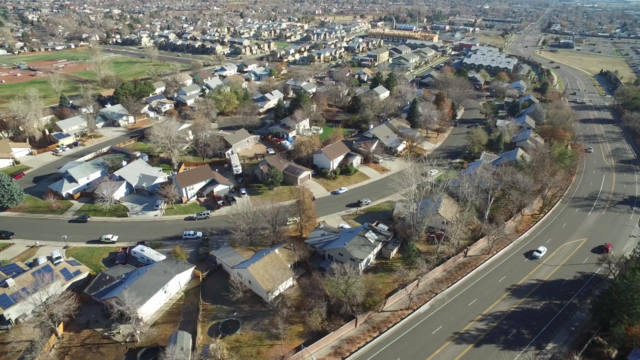 Aerial view across houses toward fields and distant neighborhoods.