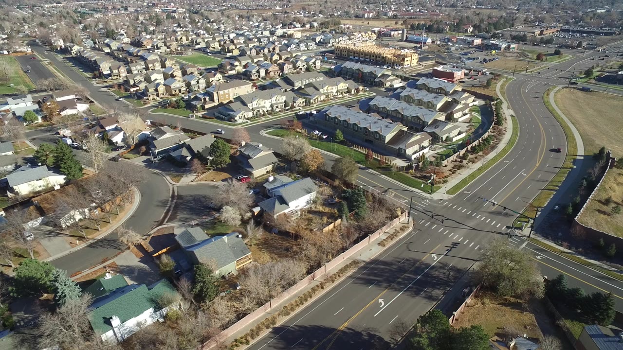 Aerial view of a suburban road intersection and nearby homes.