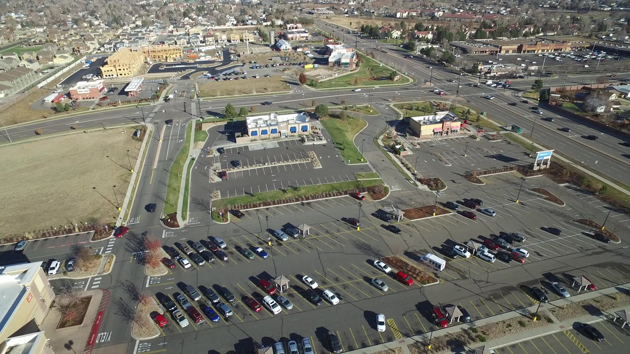 Aerial view of roads, parking lots, and low commercial buildings.