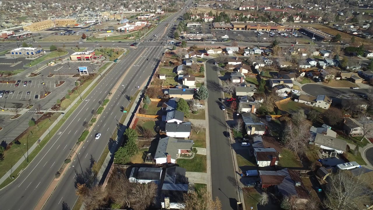 Aerial view of suburban streets, homes, parking lots, and a divided road.