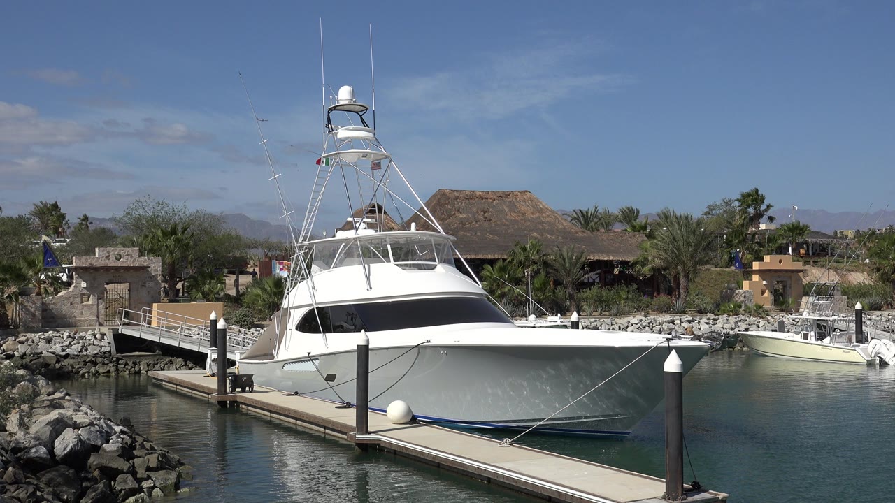 White yacht moored beside a floating jetty in a marina