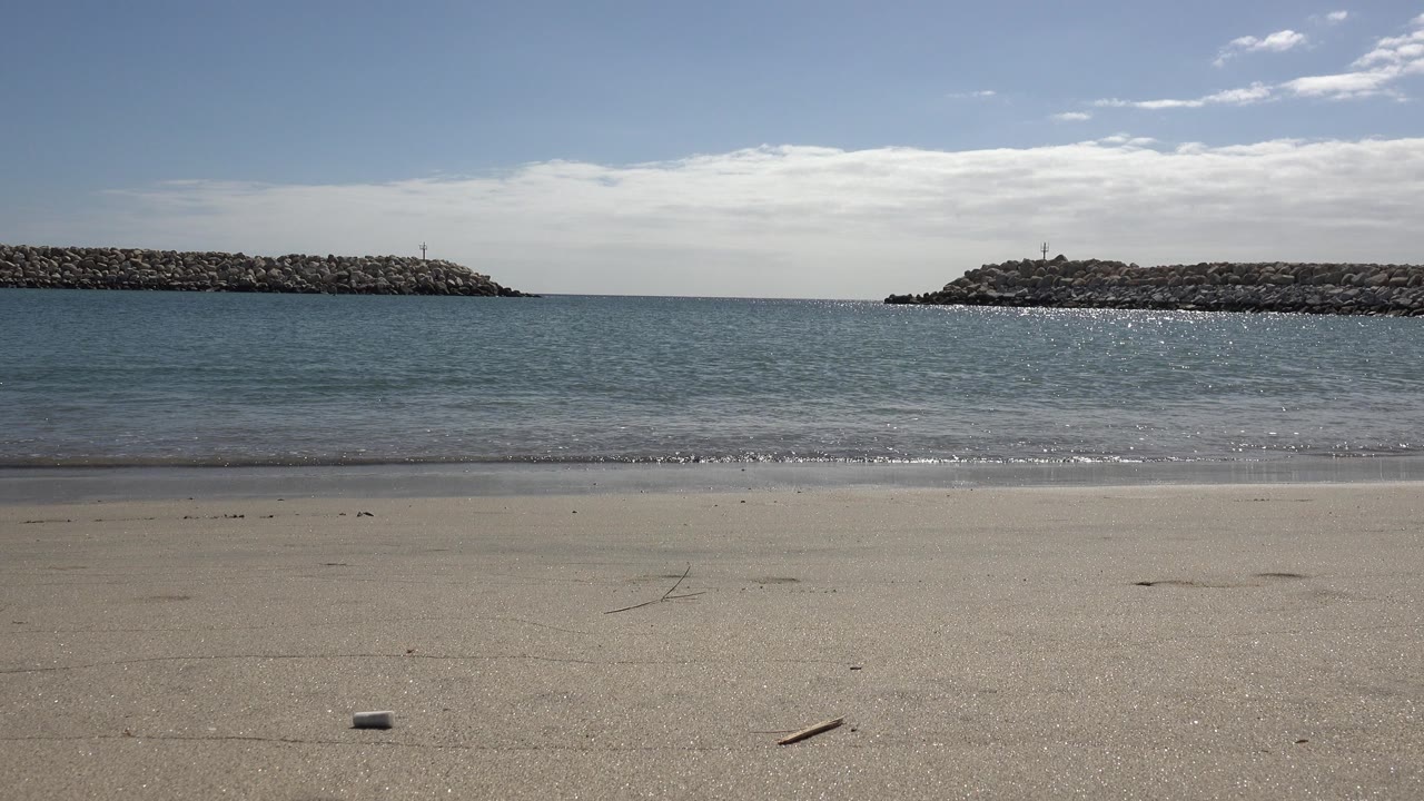 One second into the San Jose del Cabo clip, a small wave line sits closer to the shore beneath bright sky, with no visible people.