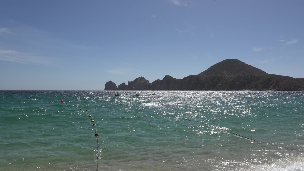 Calm blue-green water with horizon rocks and a foreground line