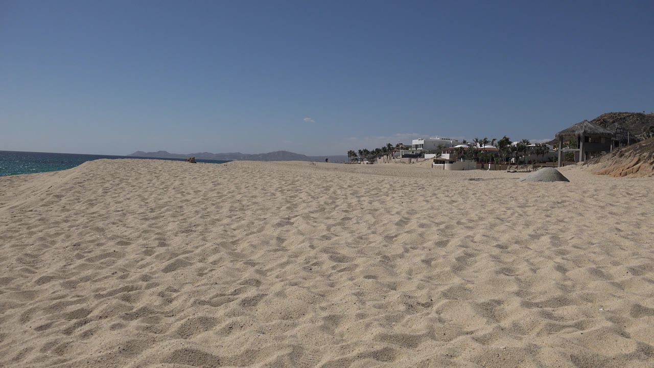 Sandy beach with ocean on the left and buildings on the right